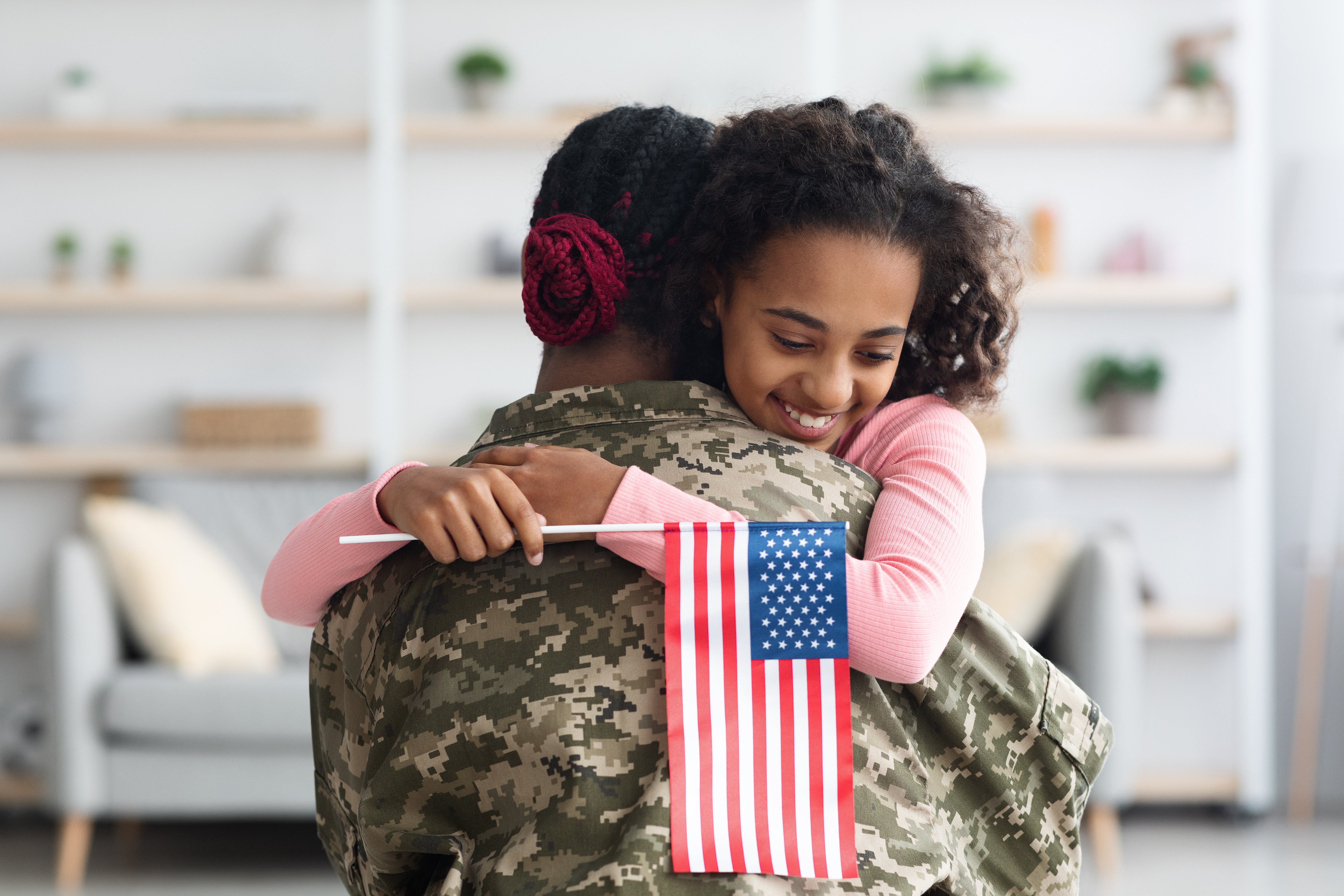 Military member hugs student